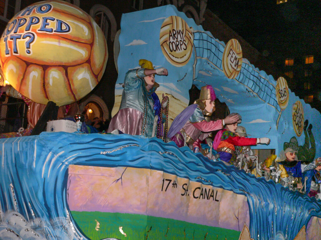 A Mardi Gras float, six months after Hurricane Katrina destroyed New Orleans, asks "Who Dropped It?" meaning the ball that allowed this to happen. Army Corps? FEMA? 