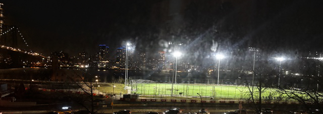 Ball field light glaring late into the night in East River Park on the Lower East Side of Manhattan.